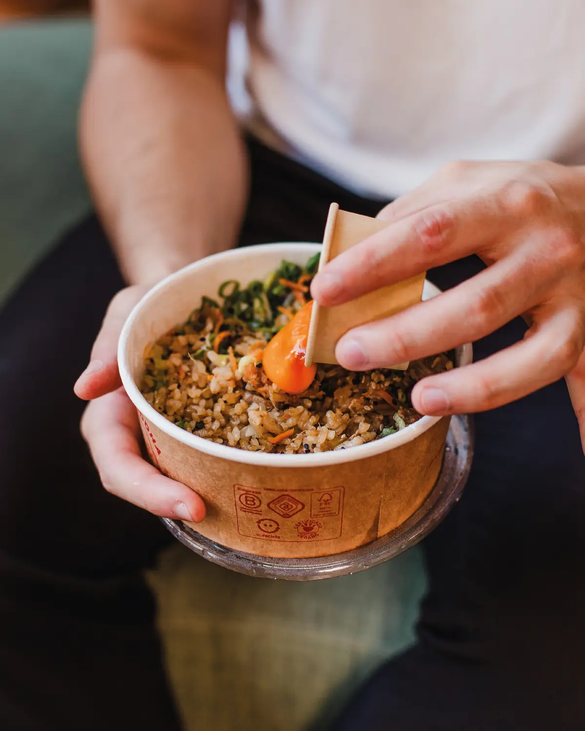 Fried rice do Fat Buddha num bowl de kraft, nas mãos de um cliente